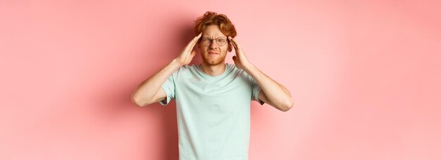 Foto portret van een jonge vrouw die tegen een roze achtergrond staat