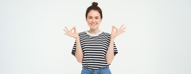 Foto portret van een jonge vrouw die tegen een witte achtergrond staat