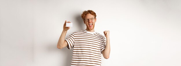 Foto portret van een jonge vrouw die tegen een witte achtergrond staat