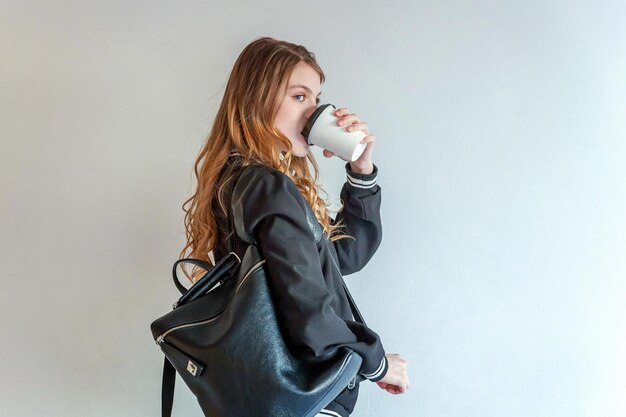 Portret van een jonge vrouw die tegen een witte achtergrond staat
