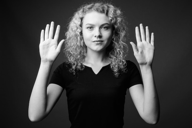 Foto portret van een jonge vrouw die tegen een zwarte achtergrond staat