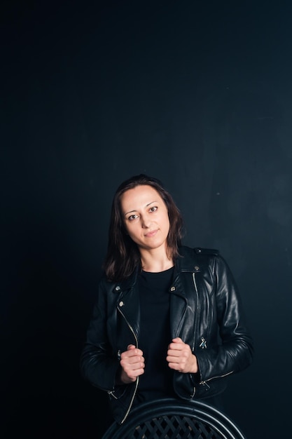 Portret van een jonge vrouw die tegen een zwarte achtergrond staat