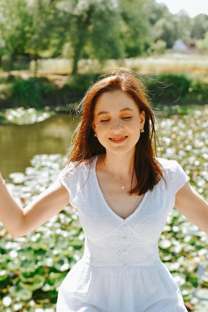 Foto portret van een jonge vrouw die tegen het meer staat