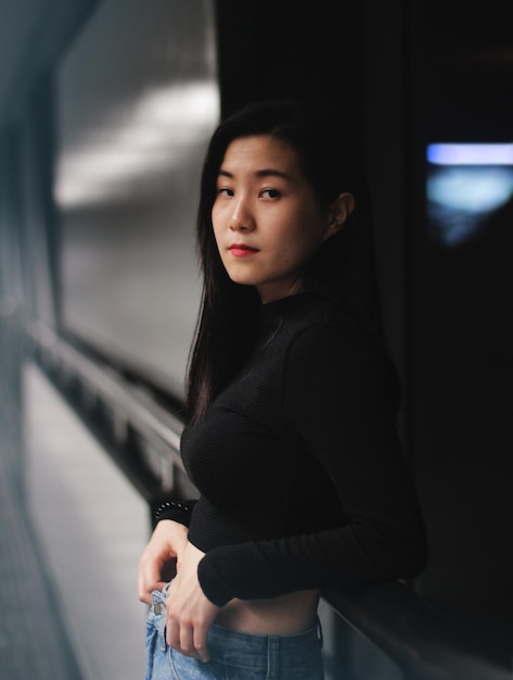 Portret van een jonge vrouw die tegen het raam staat