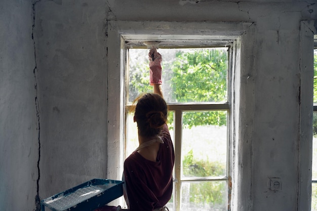 Foto portret van een jonge vrouw die tegen het raam staat