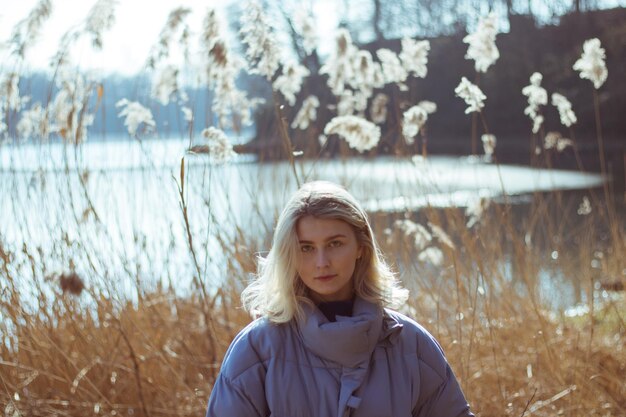 Portret van een jonge vrouw die tegen planten staat