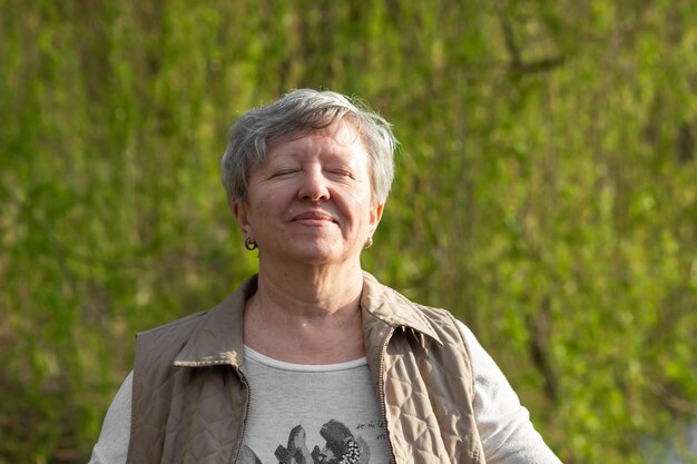 Foto portret van een jonge vrouw die tegen planten staat