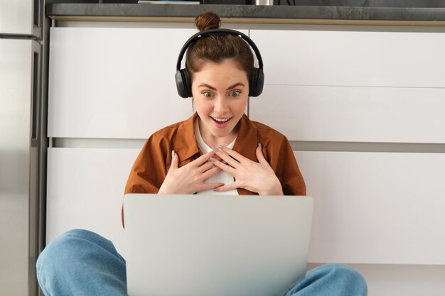 Foto portret van een jonge vrouw die thuis een laptop gebruikt