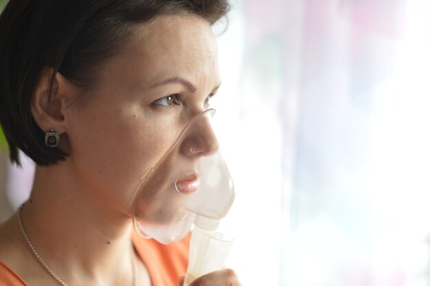 Portret van een jonge vrouw die thuis inhaleert