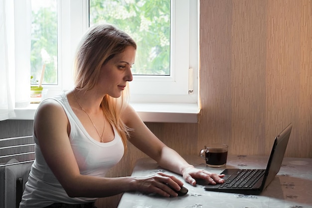 Portret van een jonge vrouw die thuis online werkt