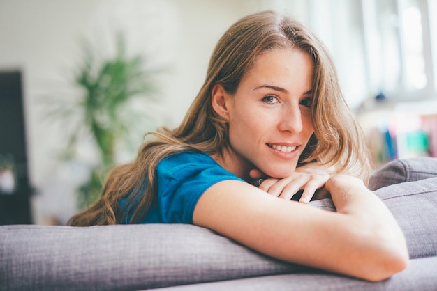 Portret van een jonge vrouw die thuis ontspant