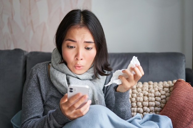 Foto portret van een jonge vrouw die thuis op de bank zit