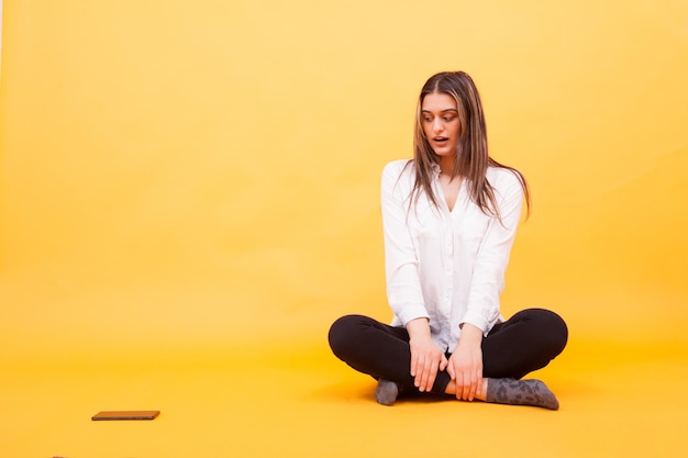 Portret van een jonge vrouw die thuis op de bank zit