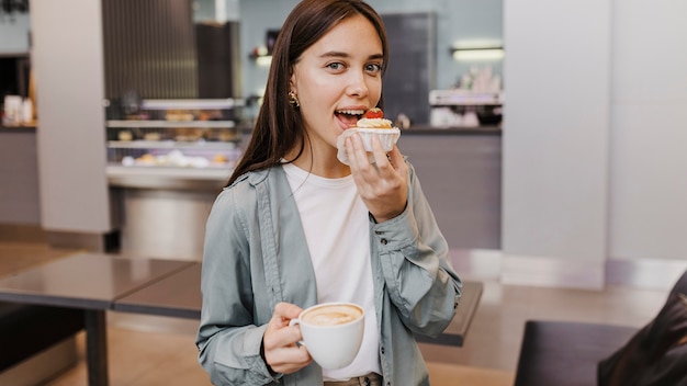 Foto portret van een jonge vrouw die van koffie geniet