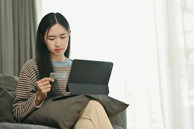 Foto portret van een jonge vrouw die via het internet bestellingen doet op een digitale tablet of met een creditcard betaalt