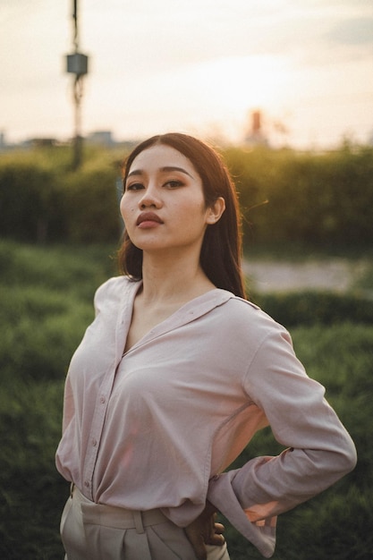 Foto portret van een jonge vrouw die wegkijkt terwijl ze op het veld staat