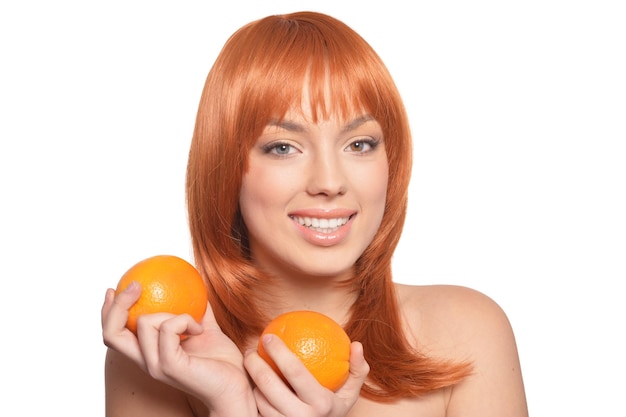 Portret van een jonge vrouw die zich voordeed met sinaasappelen geïsoleerd op een witte achtergrond