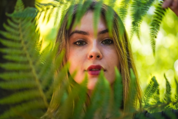 Portret van een jonge vrouw in de natuur in een natuurpark met wat varenbladeren