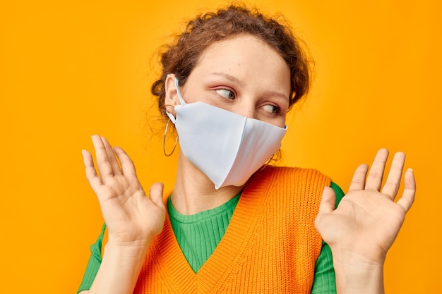 Portret van een jonge vrouw in een geel t-shirt met medische maskerbescherming bijgesneden weergave ongewijzigd