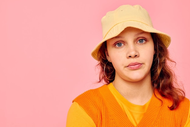 Foto portret van een jonge vrouw in een oranje trui in gele hoed handgebaar bijgesneden weergave ongewijzigd