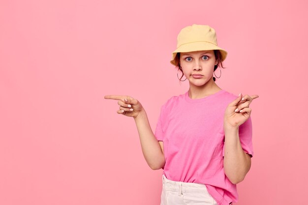Portret van een jonge vrouw in een roze T-shirt en hoed Jeugdmode