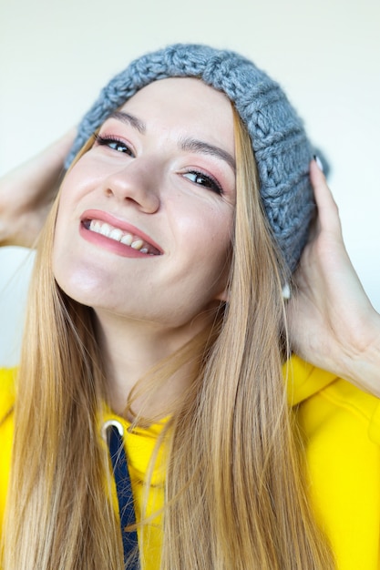 Portret van een jonge vrouw in een wintermuts en een felgele hoodie