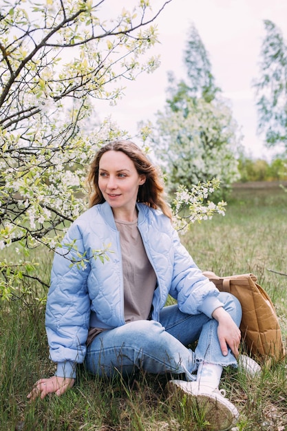 Portret van een jonge vrouw in het voorjaar in een park