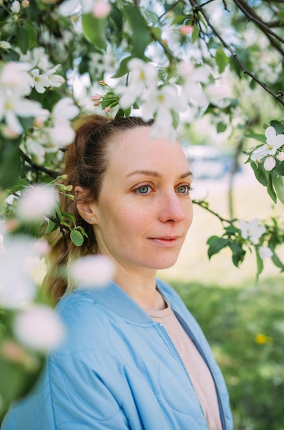 Portret van een jonge vrouw in het voorjaar in een park