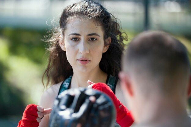 Portret van een jonge vrouw in sportkleding bij bokstraining in het zomerpark