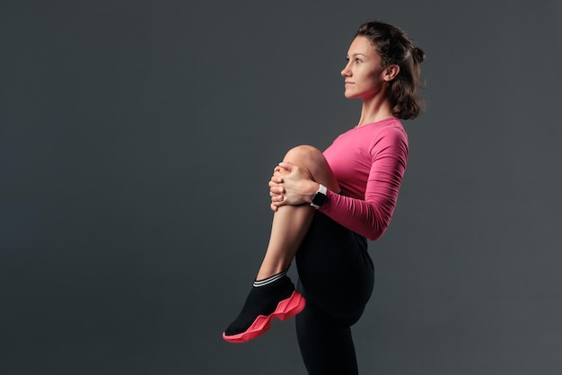 Portret van een jonge vrouw in sportkleding die fitnessoefening doet