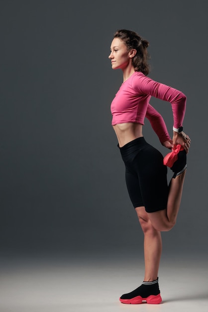 Portret van een jonge vrouw in sportkleding die fitnessoefening doet