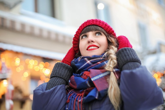 Portret van een jonge vrouw in stijlvolle warme kleding buiten op winterdag