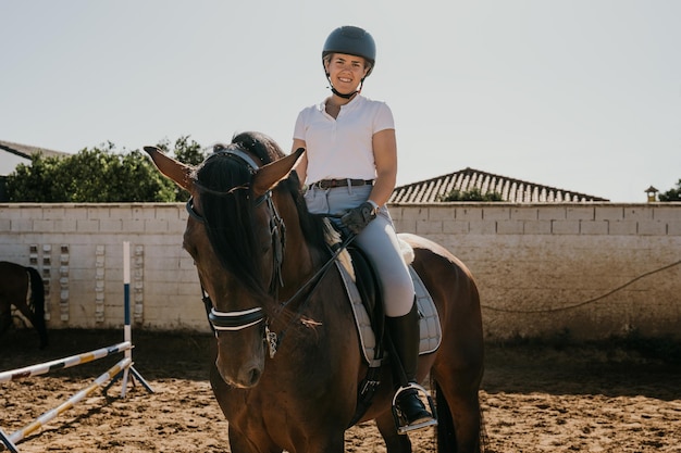 Portret van een jonge vrouw in uniform en gezeten op haar paard