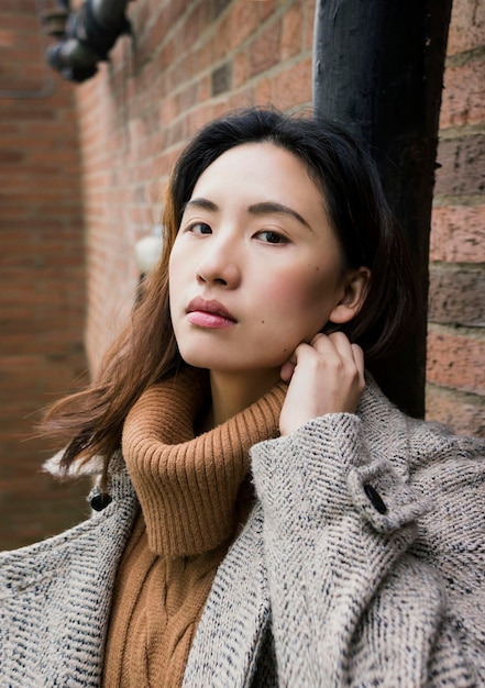 Portret van een jonge vrouw in warme kleding in de stad
