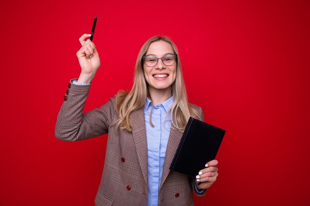 Portret van een jonge vrouw in zakelijke kleding met een dagboek en een pen