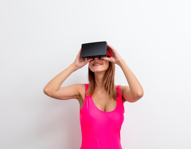 Portret van een jonge vrouw in zwembroek met virtual reality-bril op witte achtergrond. Zomerseizoen afbeelding concept