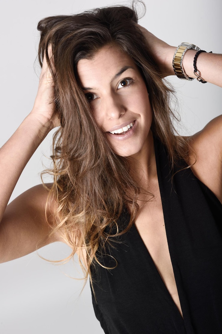 Foto portret van een jonge vrouw in zwembroek tegen een grijze achtergrond