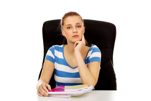 Foto portret van een jonge vrouw met boeken op een witte achtergrond