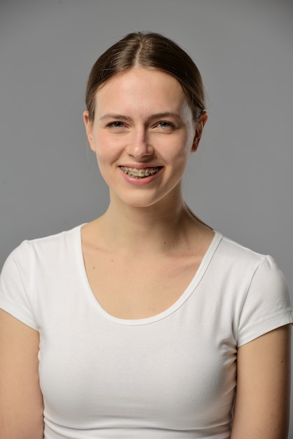 Portret van een jonge vrouw met bretels in een wit T-shirt
