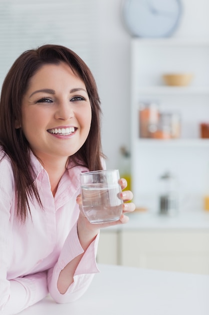 Portret van een jonge vrouw met een glas water