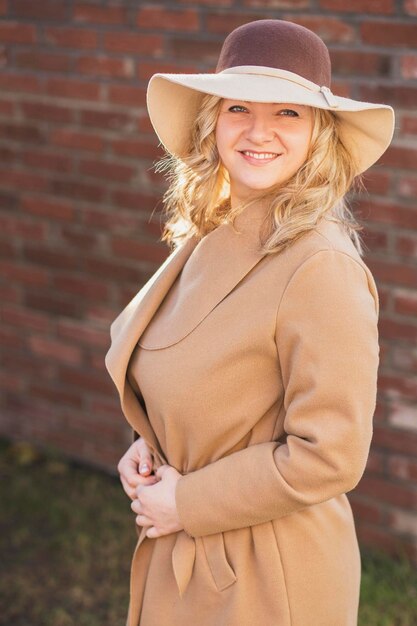 Foto portret van een jonge vrouw met een hoed die buiten staat