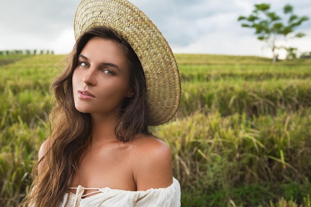 Portret van een jonge vrouw met een hoed