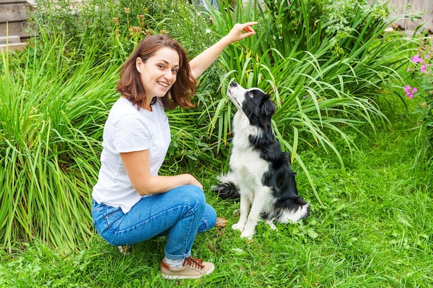 Portret van een jonge vrouw met een hond op een grasveld