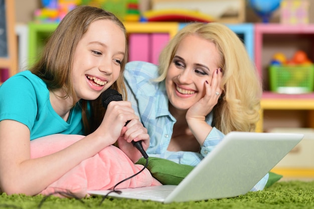 Foto portret van een jonge vrouw met een meisje dat laptop gebruikt