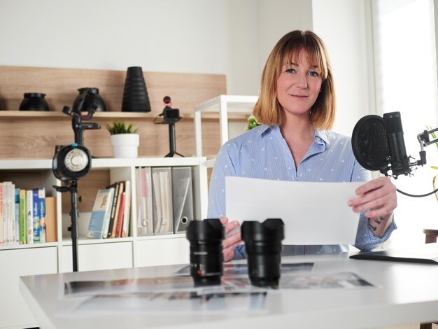 Portret van een jonge vrouw met een mobiele telefoon terwijl ze op tafel zit