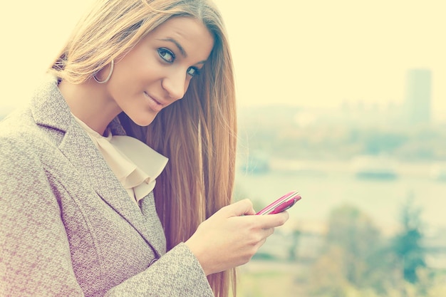 Portret van een jonge vrouw met een mobiele telefoon