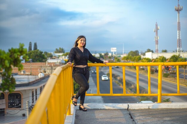 Portret van een jonge vrouw met een positieve houding op een voetgangersbrug Zonsondergang met blauwe lucht