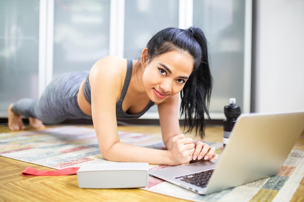 Portret van een jonge vrouw met een telefoon terwijl ze op tafel zit