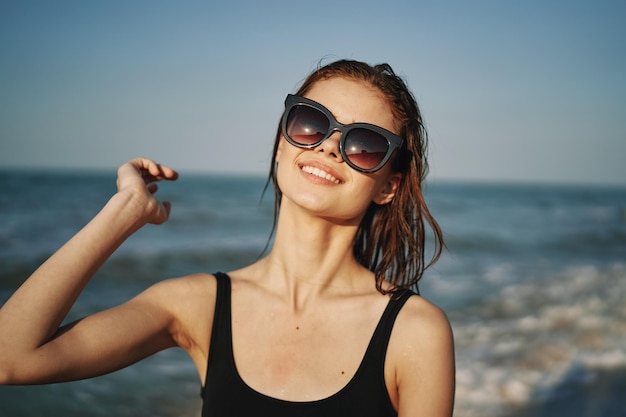 Portret van een jonge vrouw met een zonnebril op het strand