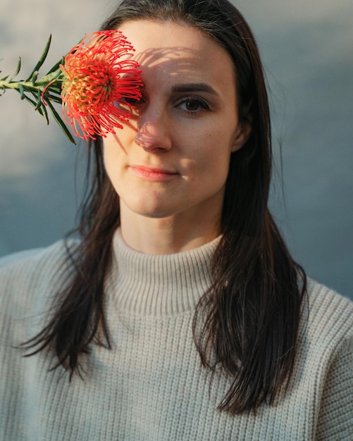 Portret van een jonge vrouw met gesloten ogen die tegen de muur staat
